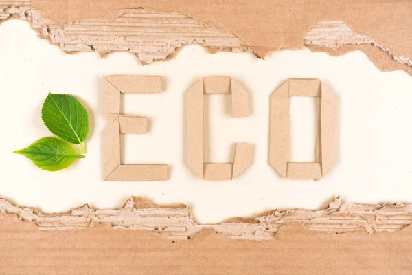 Sustainable paper packaging concept. Text ECO made with paper letters and sheets of corrugated cardboard as eco background for ecological project or paper packaging industry