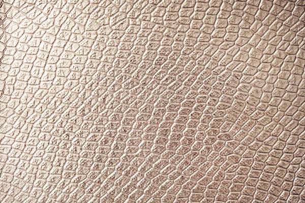 Golden reptile skin texture as background for your project with copy space for text. Artificial textile texture