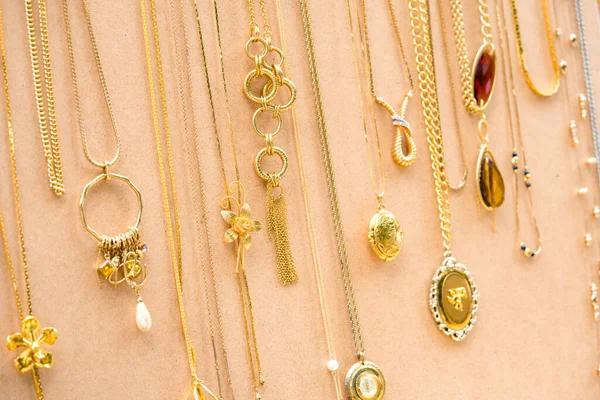 Vintage imitation jewelry background. Old-fashioned necklaces, chains and elegant pendants. Vintage goods at flea market. Garage sale concept. Selective focus