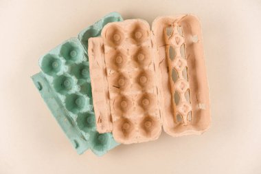 Eko posalı yumurta kutuları. Açık kahverengi arka planda hamurdan ve samandan yapılmış çevre dostu yumurta kutuları. Sürdürülebilir gıda paketleme kavramı