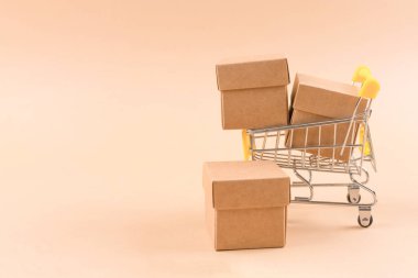 Açık kahverengi arkaplan üzerinde fotokopi alanı olan karton kutularla dolu alışveriş tepsisi. Sürdürülebilir ambalaj kavramı