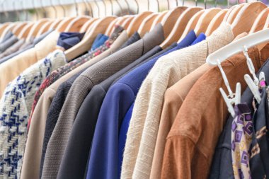 Askıdaki kıyafetler - ikinci el kıyafet mağazası ya da ikinci el alışveriş konsepti. Kıyafet kiralama servisi. Bit pazarında satılık vintage ceketler. Seçici odak