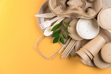 Turuncu arka planda, sürdürülebilir kağıt gıda ambalajlı çevre dostu sofra takımı. Sokak yiyecekleri ambalajı, geri dönüşümlü kağıt takımı, sıfır atık ambalaj kavramı