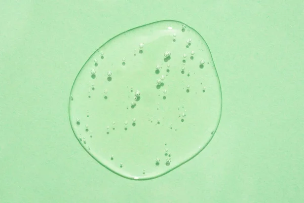 Tropfen Transparentes Kosmetikgel Oder Flüssigkeit Mit Blasen Auf Grünem Hintergrund — Stockfoto