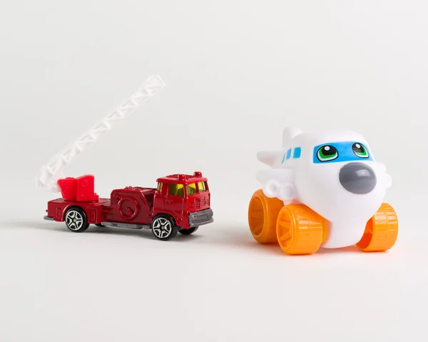 Caminhão de bombeiros vermelho e um brinquedo de avião no fundo branco — Fotografia de Stock