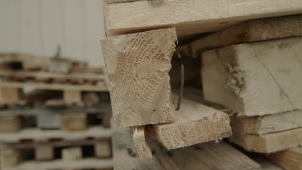 나무 막대가 있는 작은 집, 널빤지가 있는 커다란 창고. 제재소에 있는 나무 판자 기둥들 이었습니다. 야외에서 판자를 톱질하기 위한 재봉사. 목재로 쌓아 올린 벽돌 이 건축 자재를 평평하게 만든다. — 비디오