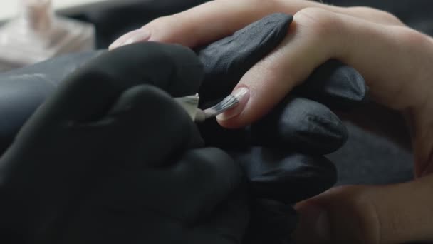 De meester in zwarte latex maakt het meisje een manicure. Handen dicht. Schoonheidssalon en handverzorging. — Stockvideo