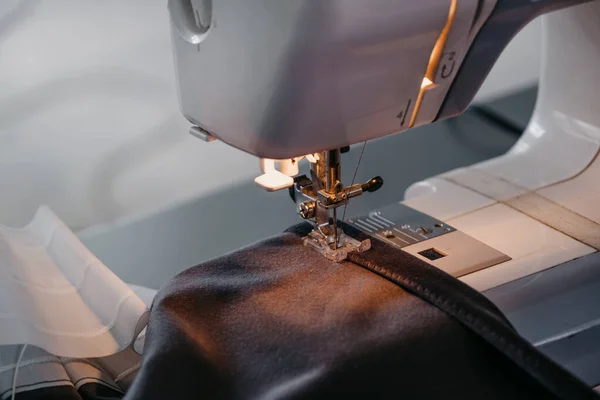 Máquina de costura, close-up de uma agulha e tecido preto. Fotos De Bancos De Imagens
