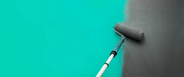 Close-up-Walze mit grauer Farbe zum Streichen der Wände. Reparaturen. Blaue Wand. Hintergrund. Bildschirmschoner für die Website. — Stockfoto