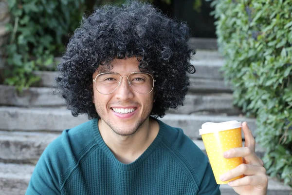 巻き毛の黒い髪をしたハンサムな若い男のクローズアップポートレート屋外コーヒーの紙コップ — ストック写真