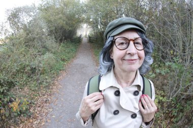 Açık havada gri saçlı yaşlı bir kadının portresi.