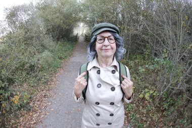 Açık havada gri saçlı yaşlı bir kadının portresi.