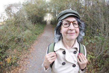 Açık havada gri saçlı yaşlı bir kadının portresi.