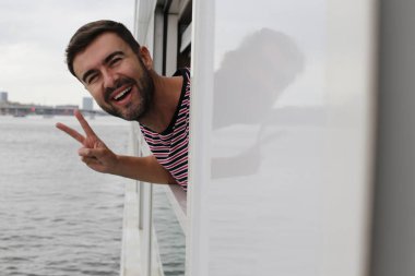 Seyahat ederken pencereden dışarı bakan yakışıklı genç adamın yakın plan portresi. 