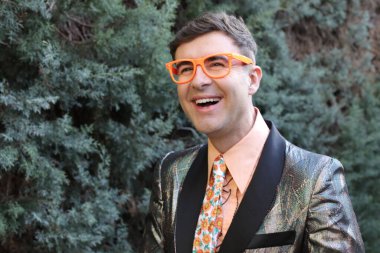 Açık havada parlak ceketli yakışıklı bir adamın yakın plan portresi.