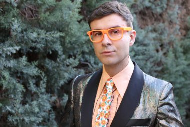 Açık havada parlak ceketli yakışıklı bir adamın yakın plan portresi.