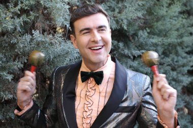 Dışarıda rumba yapan ceketli yakışıklı bir gencin yakın plan portresi.