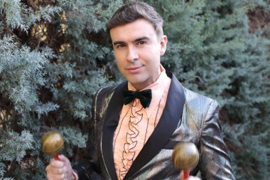 Dışarıda rumba yapan ceketli yakışıklı bir gencin yakın plan portresi.