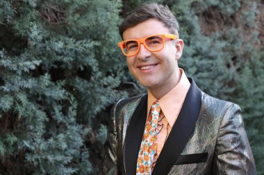 Açık havada parlak ceketli yakışıklı bir adamın yakın plan portresi.