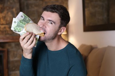 Elinde Euro banknotları olan yakışıklı bir delikanlının yakın plan portresi.