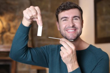 Evinde hızlı test yapan yakışıklı genç adamın yakın plan portresi.