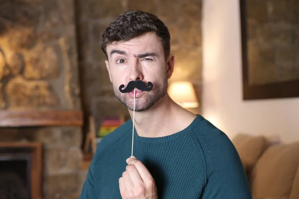Close Portrait Handsome Young Man Holding Mustache Stick Home — Stockfoto