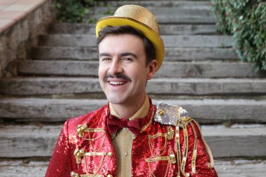 Parktaki merdivenlerin önünde renkli bir sirk elbisesi içinde yakışıklı bir genç portresi.