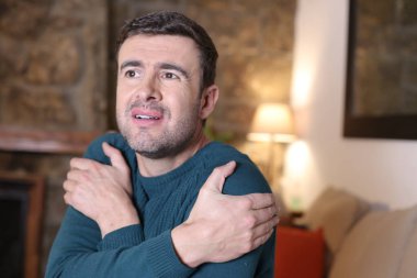 Yakışıklı genç adamın portresi evde soğuk jest yapıyor.