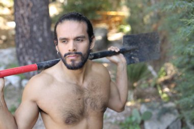 Kapıda küreği olan yakışıklı, üstsüz genç bir adamın yakın plan portresi.