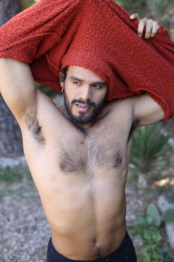 Dışarıda gömleğini çıkaran yakışıklı genç adamın yakın plan portresi.