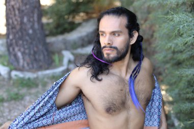 Açık havada renkli gömleği olan yakışıklı üstsüz genç adamın yakın plan portresi.