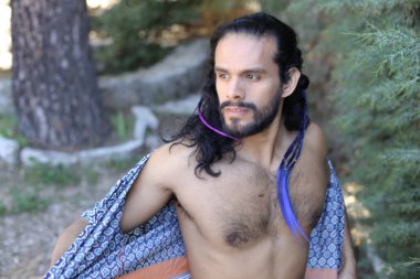 Açık havada renkli gömleği olan yakışıklı üstsüz genç adamın yakın plan portresi.