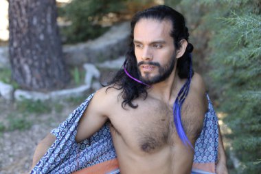 Açık havada renkli gömleği olan yakışıklı üstsüz genç adamın yakın plan portresi.