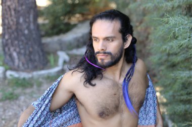 Açık havada renkli gömleği olan yakışıklı üstsüz genç adamın yakın plan portresi.