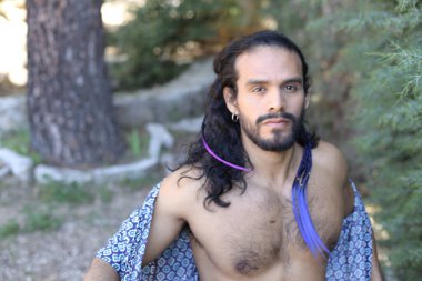 Açık havada renkli gömleği olan yakışıklı üstsüz genç adamın yakın plan portresi.