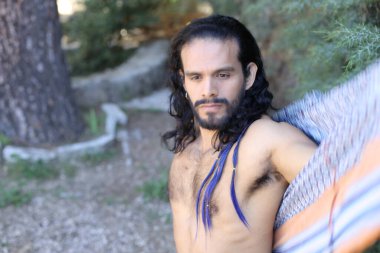 Açık havada renkli gömleği olan yakışıklı üstsüz genç adamın yakın plan portresi.