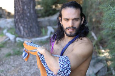 Açık havada renkli gömleği olan yakışıklı üstsüz genç adamın yakın plan portresi.