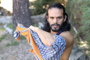 Açık havada renkli gömleği olan yakışıklı üstsüz genç adamın yakın plan portresi.