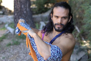 Açık havada renkli gömleği olan yakışıklı üstsüz genç adamın yakın plan portresi.