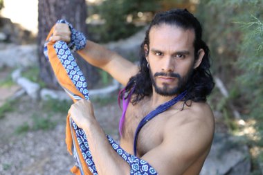 Açık havada renkli gömleği olan yakışıklı üstsüz genç adamın yakın plan portresi.