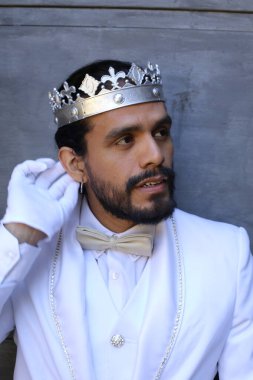 Beyaz takım elbiseli yakışıklı ve kral tacının yakın plan portresi.