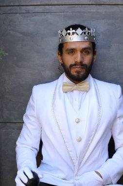 Beyaz takım elbiseli yakışıklı ve kral tacının yakın plan portresi.