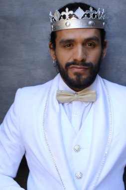 Beyaz takım elbiseli yakışıklı ve kral tacının yakın plan portresi.