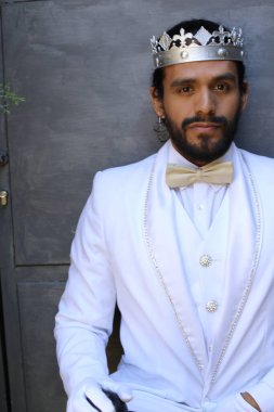 Beyaz takım elbiseli yakışıklı ve kral tacının yakın plan portresi.