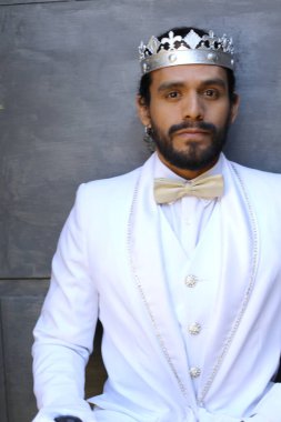 Beyaz takım elbiseli yakışıklı ve kral tacının yakın plan portresi.