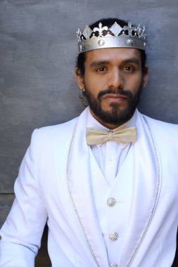 Beyaz takım elbiseli yakışıklı ve kral tacının yakın plan portresi.