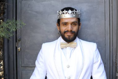 Beyaz takım elbiseli yakışıklı ve kral tacının yakın plan portresi.