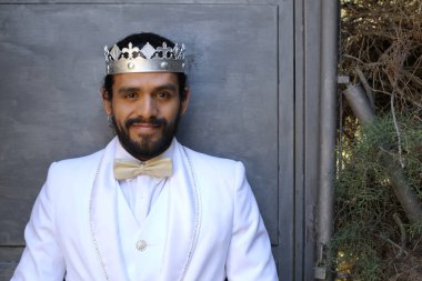 Beyaz takım elbiseli yakışıklı ve kral tacının yakın plan portresi.