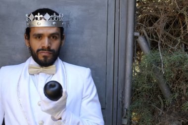 Kral tacıyla karnaval kostümlü yakışıklı genç adamın yakın plan portresi.