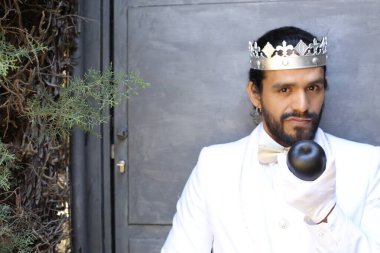 Kral tacıyla karnaval kostümlü yakışıklı genç adamın yakın plan portresi.